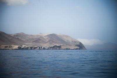 Scenic view of sea and mountains against sky