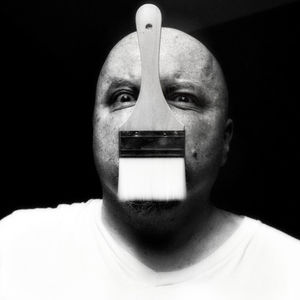 Close-up portrait of man wearing mask against black background