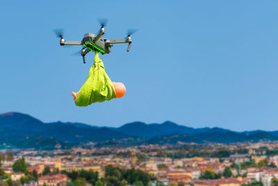 Close-up of drone flying with doll against sky