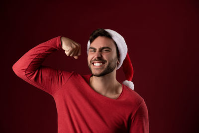 Portrait of smiling young man against black background