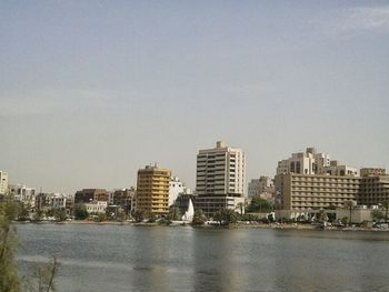 River and buildings against clear sky