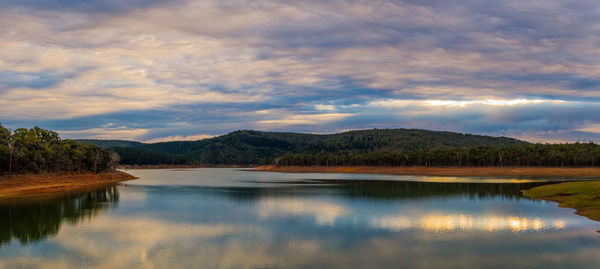 Scenic view of lake by mountains against sky