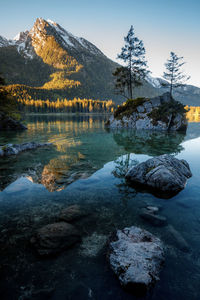 Scenic view of lake by mountain against sky