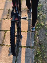 Low section of person riding bicycle on footpath