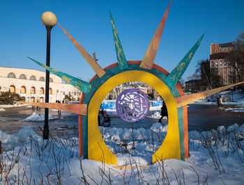 Graffiti on snow covered field against blue sky