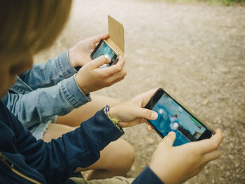 High angle view of siblings playing games on smart phone