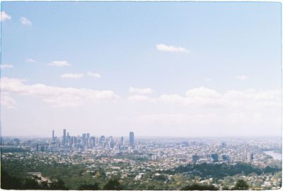 Aerial view of buildings in city against sky