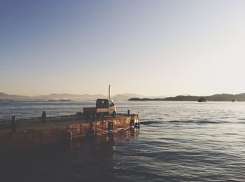 Boats in sea against clear sky