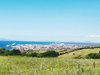 Scenic view of city by sea against sky