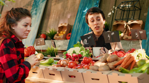 Portrait of smiling friends having food at market