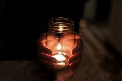 Close-up of illuminated light bulb on table