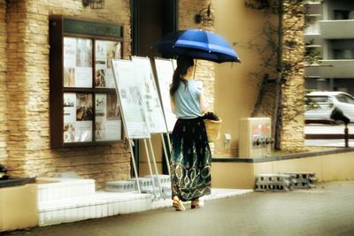 Full length of woman holding umbrella