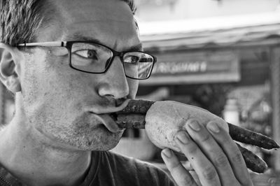 Close-up of young man eating food outdoors