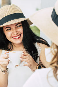 Portrait of young woman drinking coffee while sitting at home