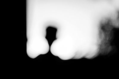 Defocused image of hand against black background