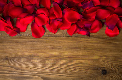 Directly above view of red rose petals on table