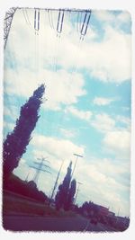 Low angle view of power lines against cloudy sky