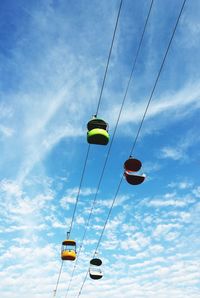 Low angle view of overhead cable cars against sky