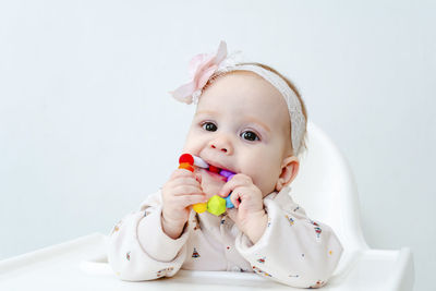 Portrait of cute girl with eyes closed against white background