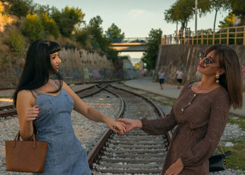 Friends dancing while standing on railroad track