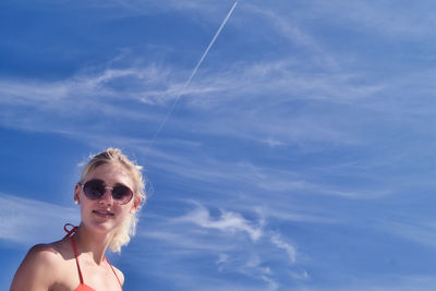 Portrait of young woman against blue sky