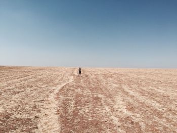 Mid distance of woman standing on field against sky