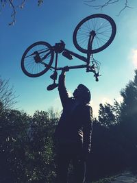 Low angle view of silhouette man standing by tree against sky