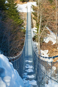 Tibetan suspension metal bridge in valli del pasubio, italy, in winter