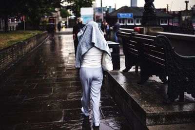 Woman standing on road in city