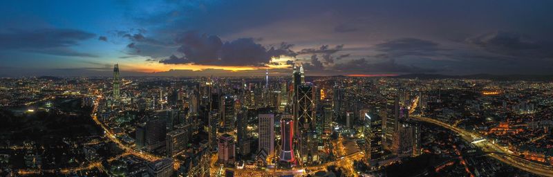 High angle view of illuminated city against sky at night