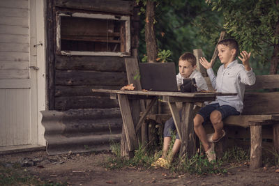 Side view of young woman using laptop while sitting in abandoned house
