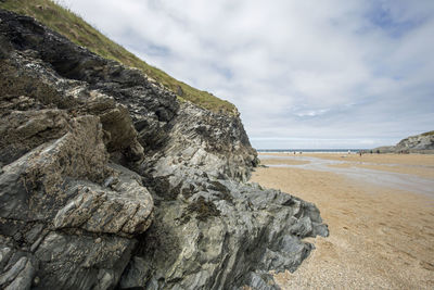 Rock formation on beach against sky