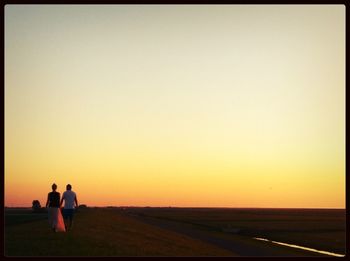 Silhouette of woman on landscape at sunset