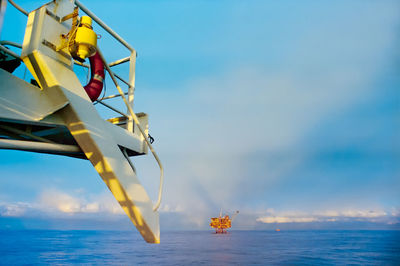 The bridge wing of an offshore supply vessel with an oil platform in the distance. 