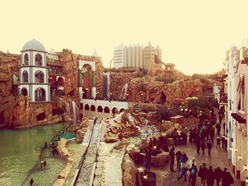 Panoramic view of people in city against clear sky