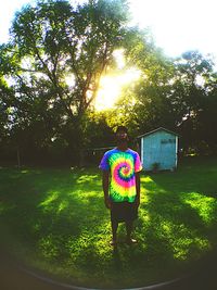 Full length rear view of girl holding umbrella in park