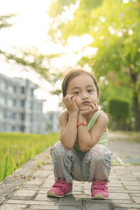 Portrait of cute girl sitting outdoors