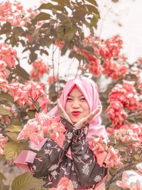 Portrait of woman with pink flowers on tree