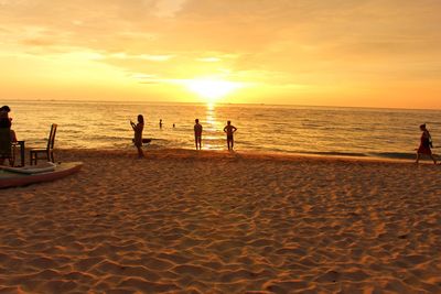 People at beach during sunset