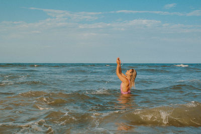 Full length of woman swimming in sea against sky