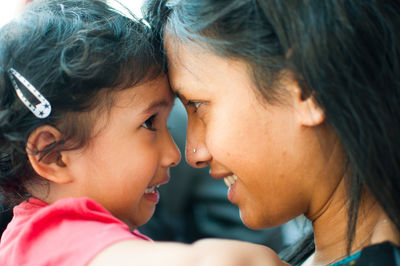 Close-up portrait of young woman with daughter