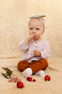 Portrait of cute girl sitting on floor at home
