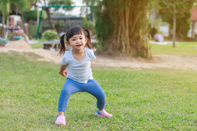 Full length of cute girl running on grass