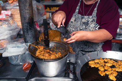 Midsection of man preparing food at market