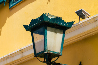 Low angle view of lamp against building