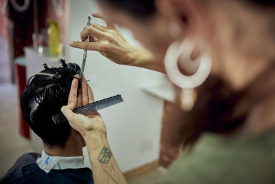 Man cutting the hair of a brown boy