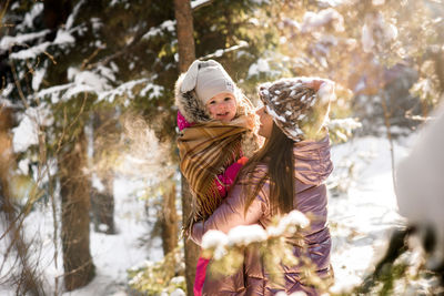 Portrait of smiling girl with mother during winter
