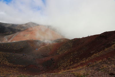 Smoke emitting from mountain against sky