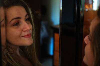 Close-up of woman smiling in front of mirror