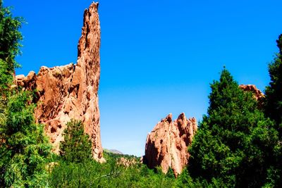 Low angle view of rock formation against clear blue sky